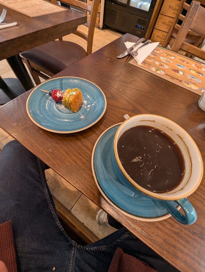 A pastry and a cup of hot chocolate on a wooden table.