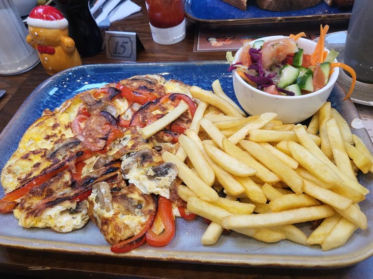 Mixed grill platter with chips, peppers and a salad bowl.
